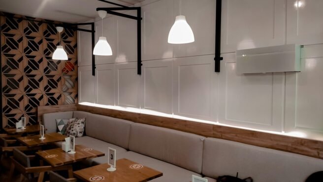 a restaurant with wooden tables and white booths