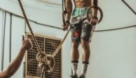 man wearing multicolored shorts while exercising on rope inside white room